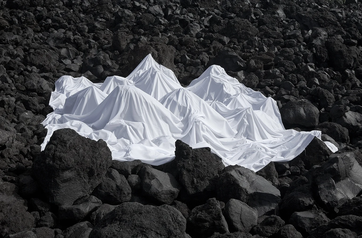 Contrasting poised sheet movement over dark and detailed rocks