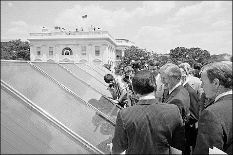 President Jimmy Carter, center, surrounded by reporters and photographers as he inspected new White House solar hot water heating system on June 20, 1979. (Harvey Georges - Associated Press)