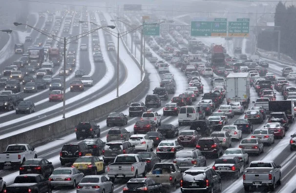 Traffic inches along the connector of Interstate’s 75 and 85 as snow blankets Metro Atlanta on Tuesday afternoon, Jan. 28, 2014 as seen from the Pryor Street overpass. (AP Photo/The Atlanta Journal-Constitution, Ben Gray)