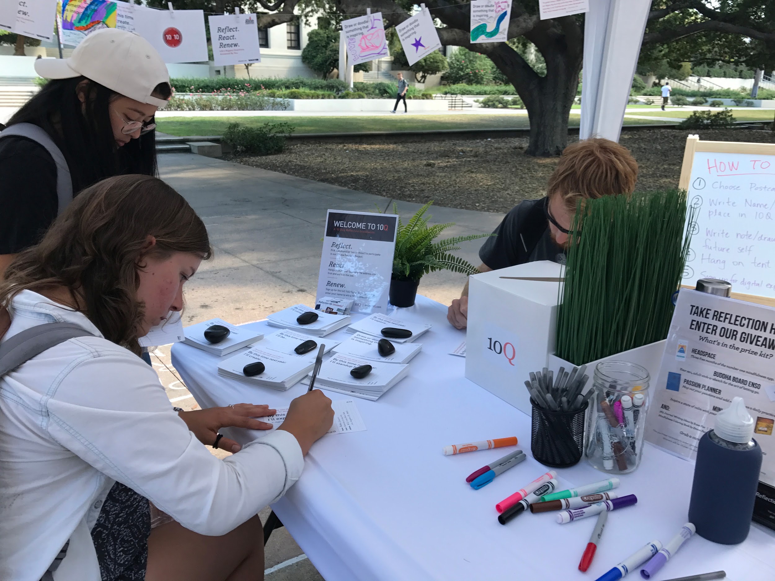 Students write personal reflections on postcards at a 10Q pop-up in Los Angeles.