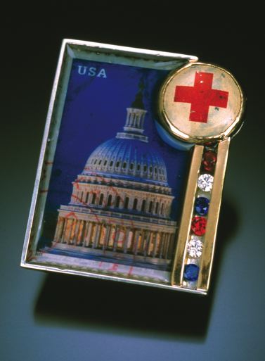 From 2001, an early brooch with a political narrative: Creating the atmosphere suggested by its title, Concern is a brooch fabricated from sterling silver, 14 karat gold, a bezel set Red Cross pinback, channel set synthetic red, white, and blue stones, and a resin encased postage stamp. 