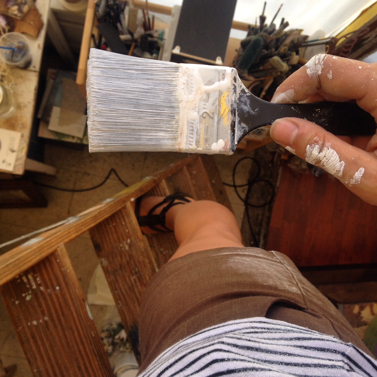 Up on a wobbly ladder, precariously painting in sandals.