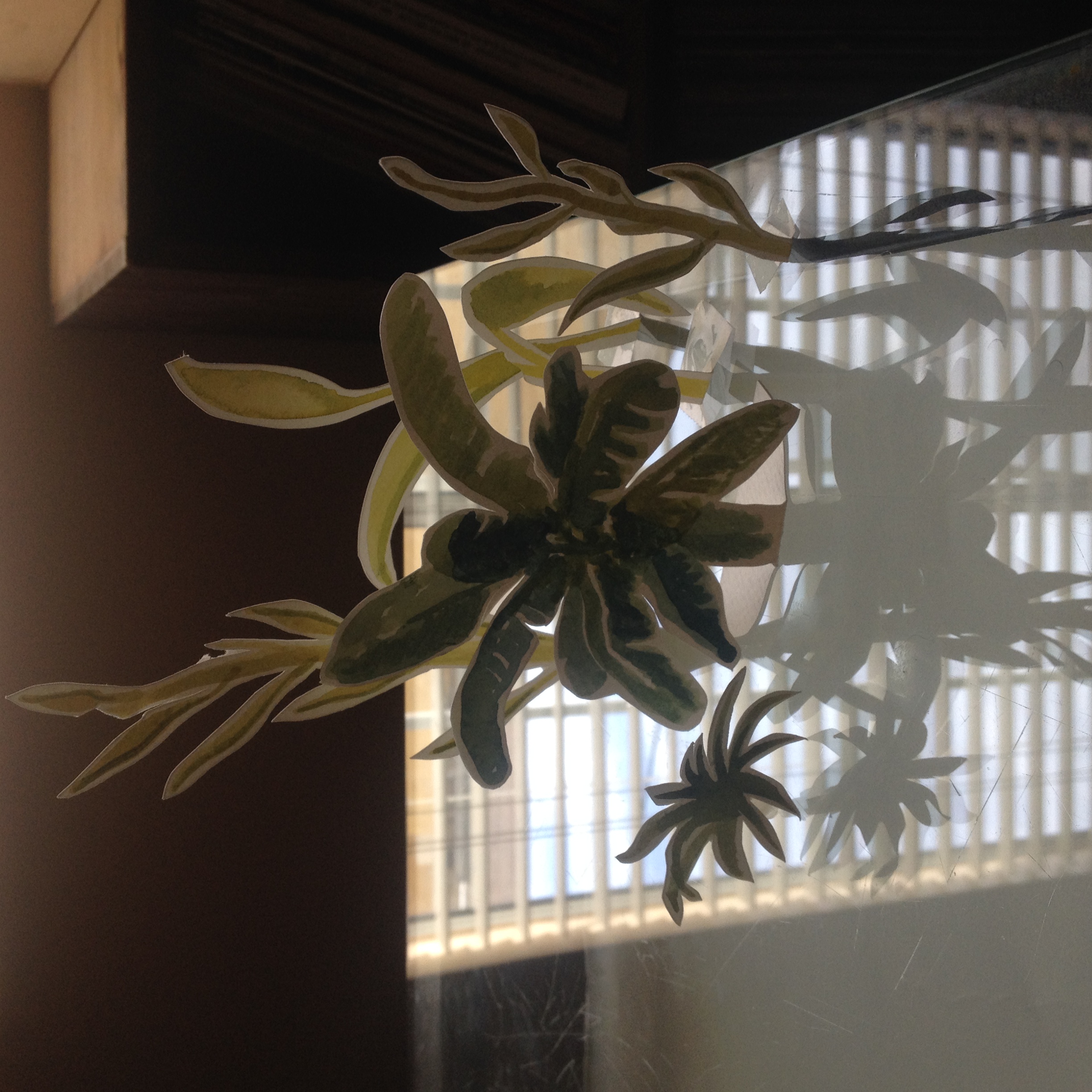 Cut paper plants with window reflection.