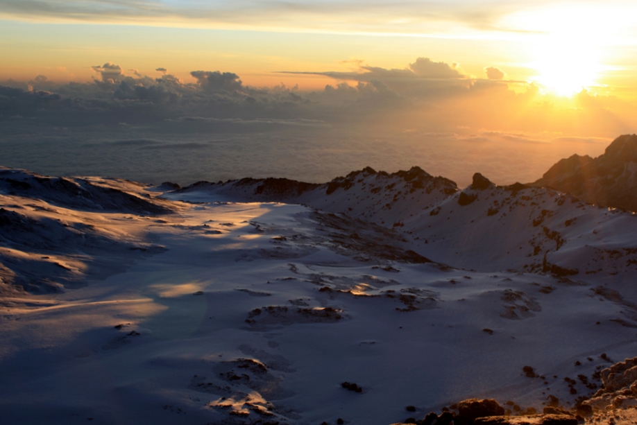 View from Uhuru peak at sunrise! Here, the snow capped summit of Kilimanjaro stands at 19,341 feet, making it the tallest peak in Africa, and the highest free standing mountain in the world. . 