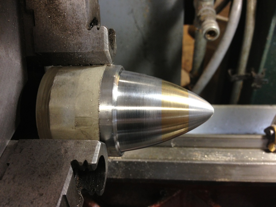  To shape the entire form, part of the larger aluminum piece was first held in the chuck of the lathe to cut the top half. 