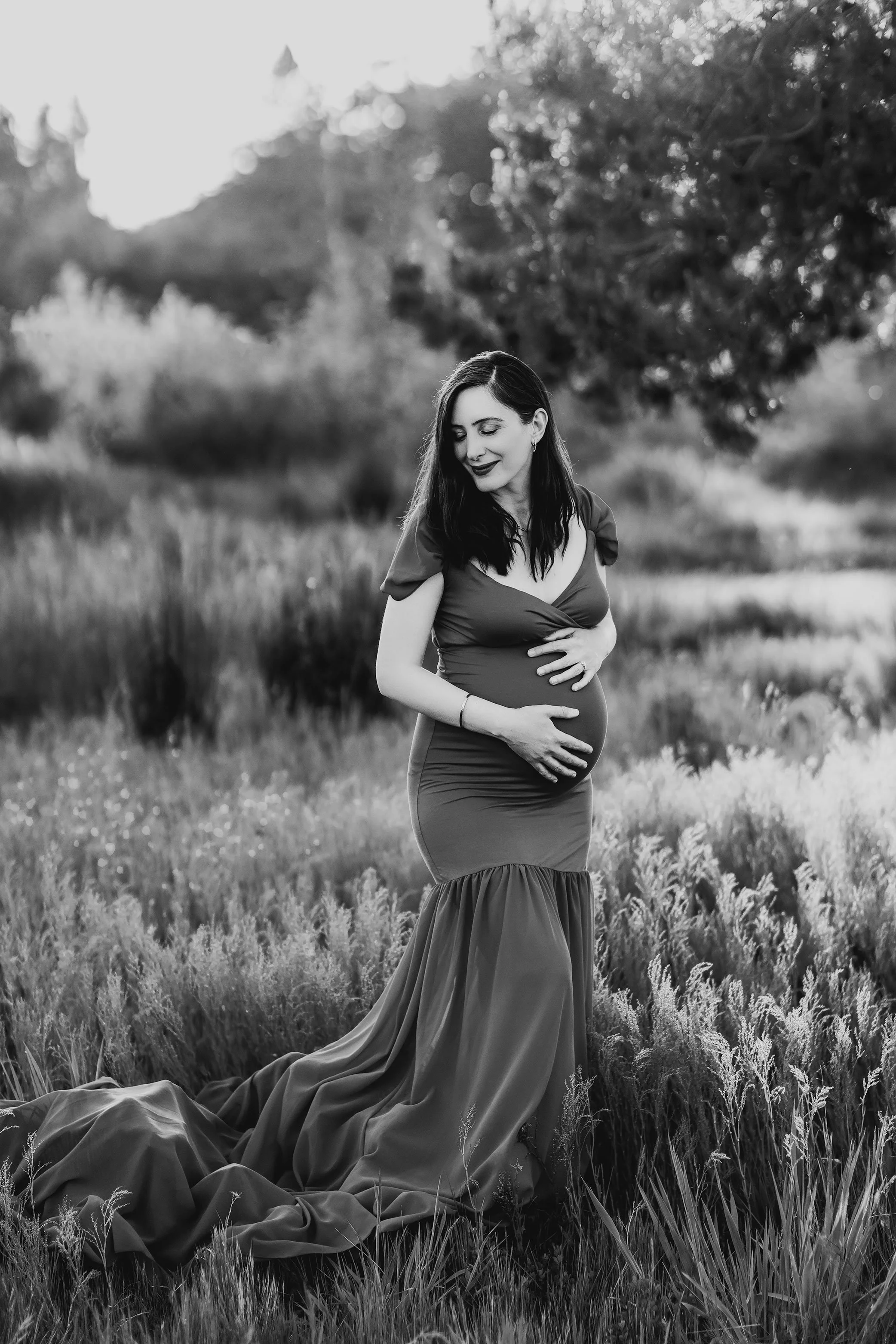 Black and white maternity portrait of pregnant mother holding belly in outdoor field session Salem Oregon