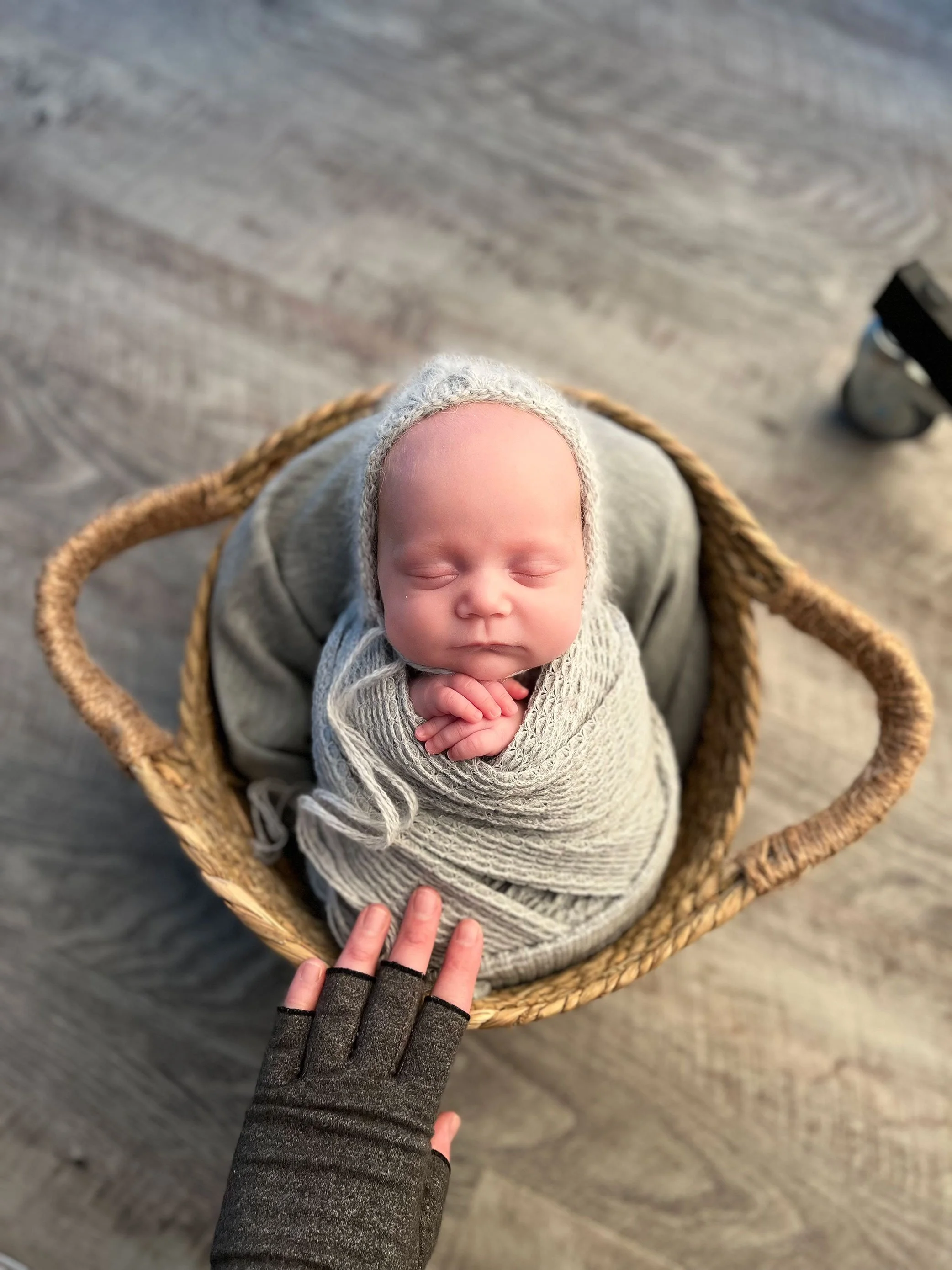 Newborn baby posed in basket during hands-on mentoring session demonstrating safe posing and styling techniques