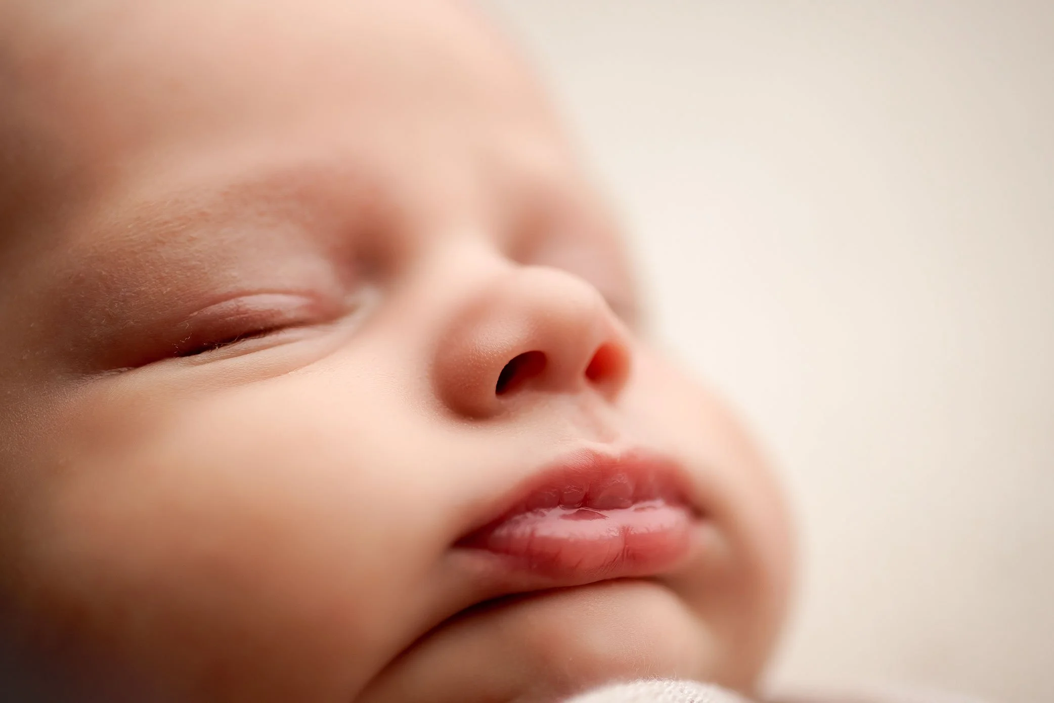 Close up macro image of newborn baby lips and nose in soft natural light