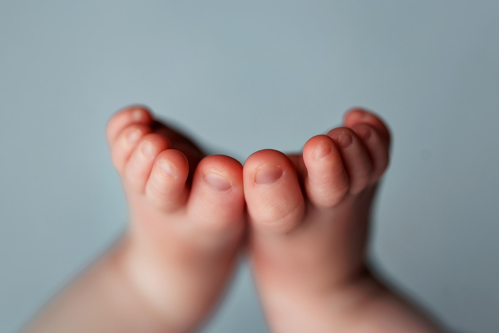 Newborn detail macro image highlighting baby's tiny toes.