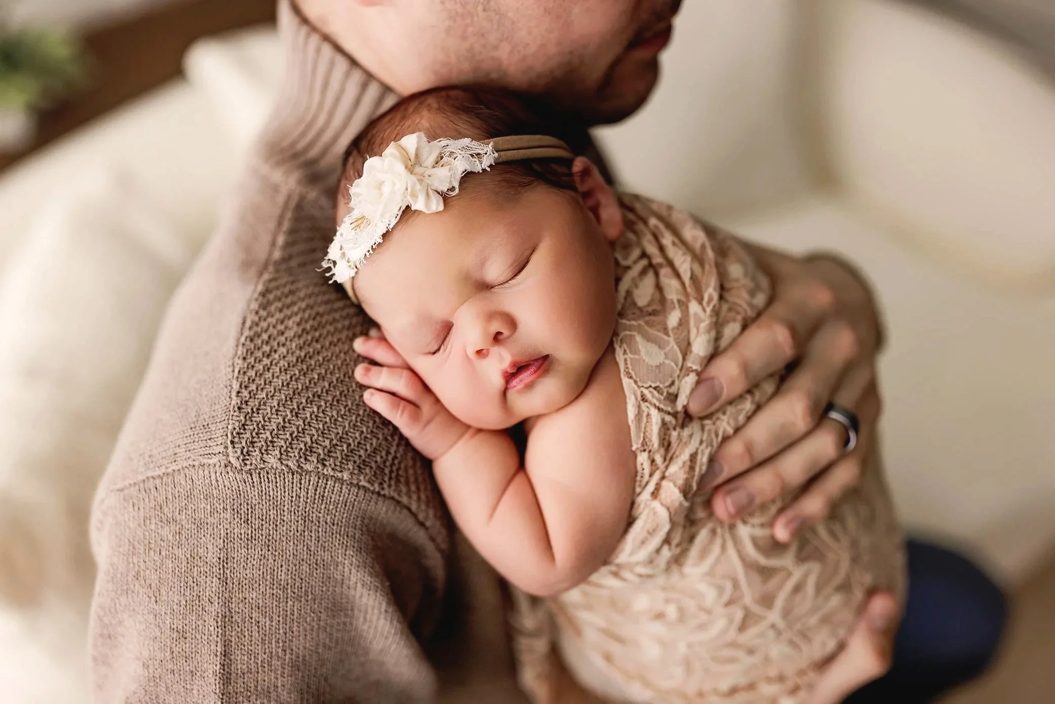 Father holding his sleeping newborn during a professional newborn photography session in Salem, Oregon.