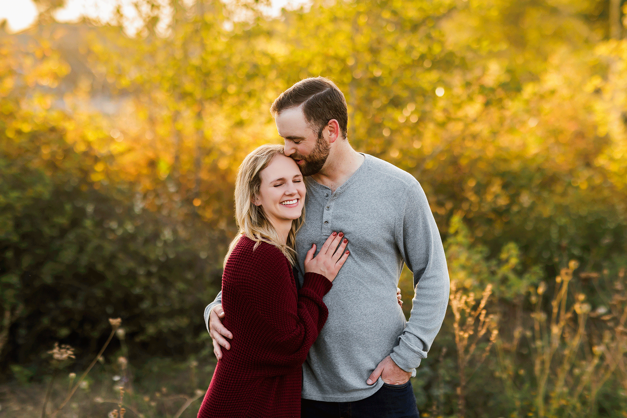 Couple embracing with woman’s hand on man’s chest during golden hour photography session in Salem Oregon