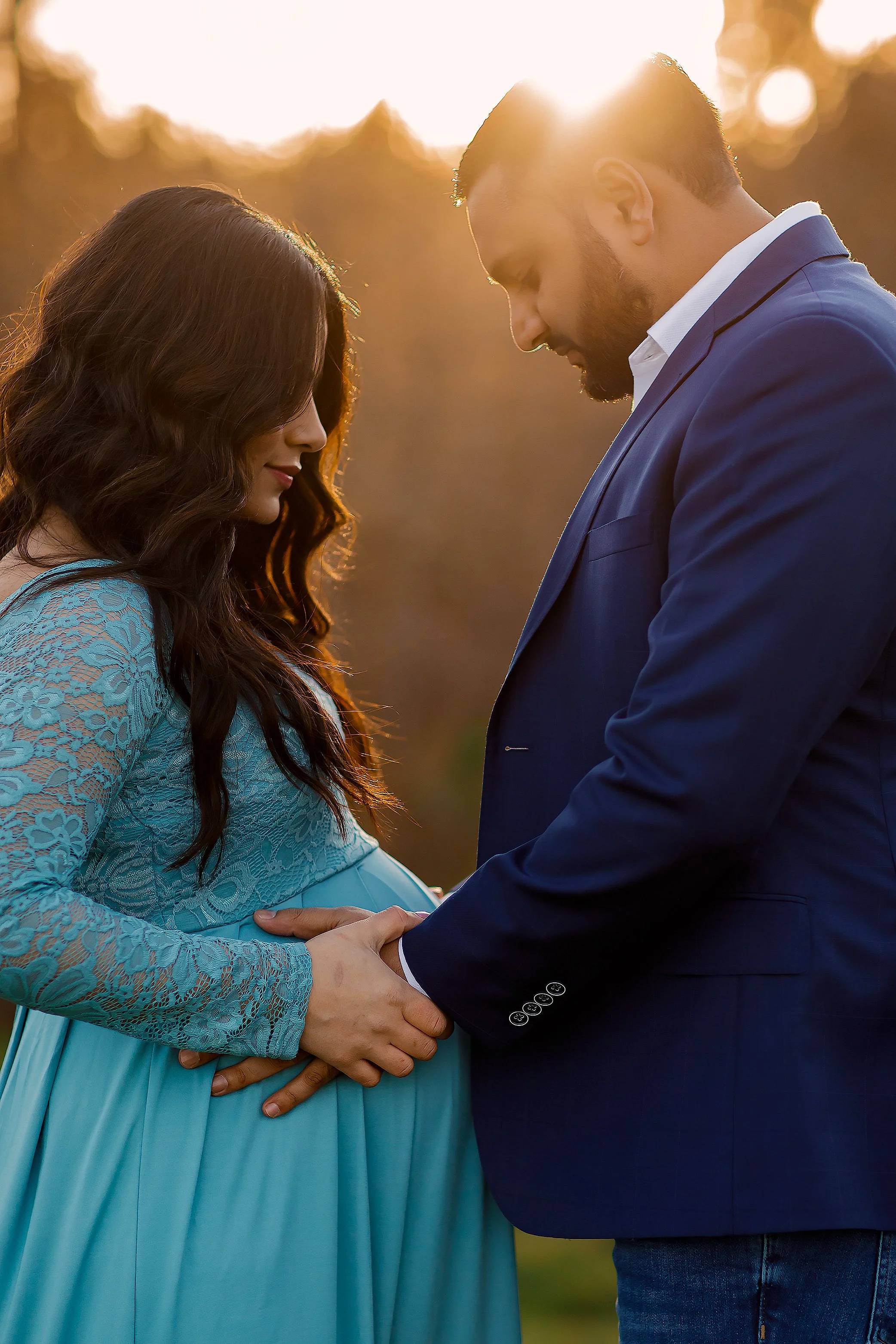 Pregnant couple holding hands on baby bump during sunset maternity session in Salem Oregon