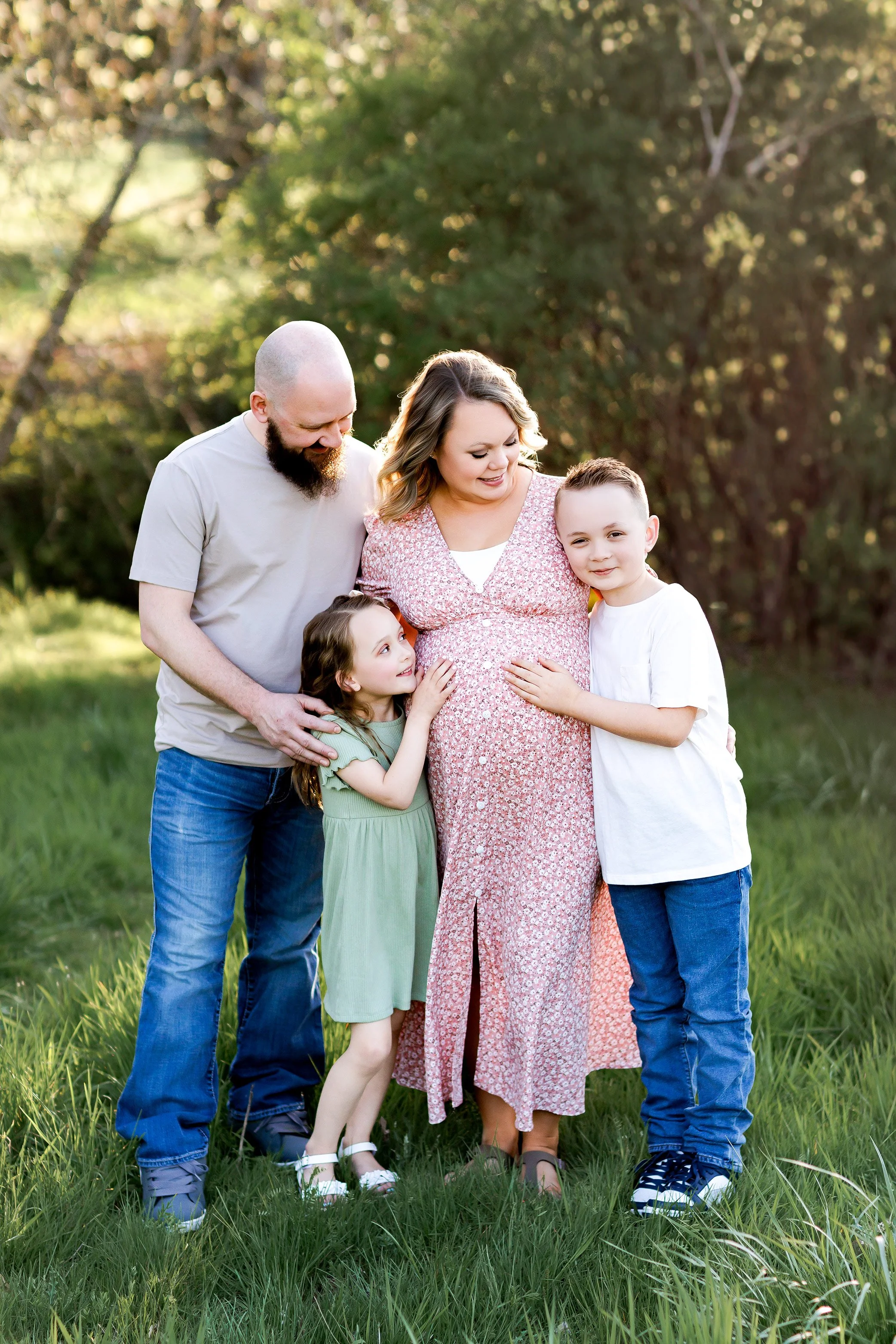 Family with two children hugging pregnant mother during outdoor maternity session in Salem Oregon.