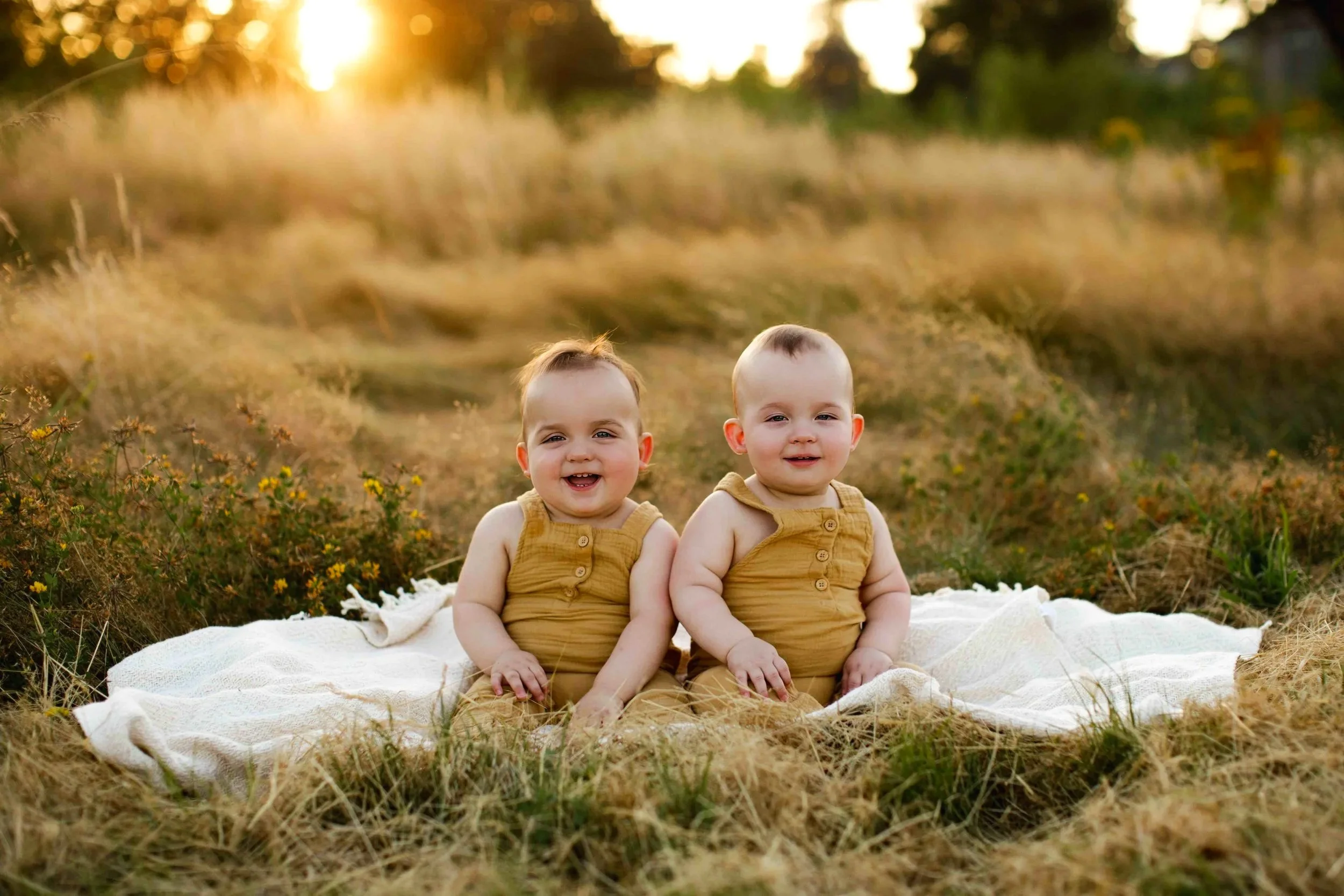 Twin babies milestone session outdoors in Salem Oregon, sitting in golden hour light smiling