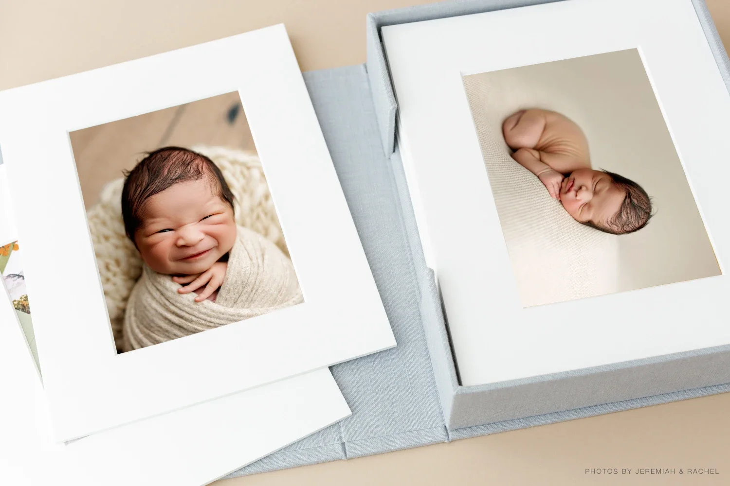 Newborn matted prints displayed in keepsake box featuring fine art baby portraits and heirloom photography products