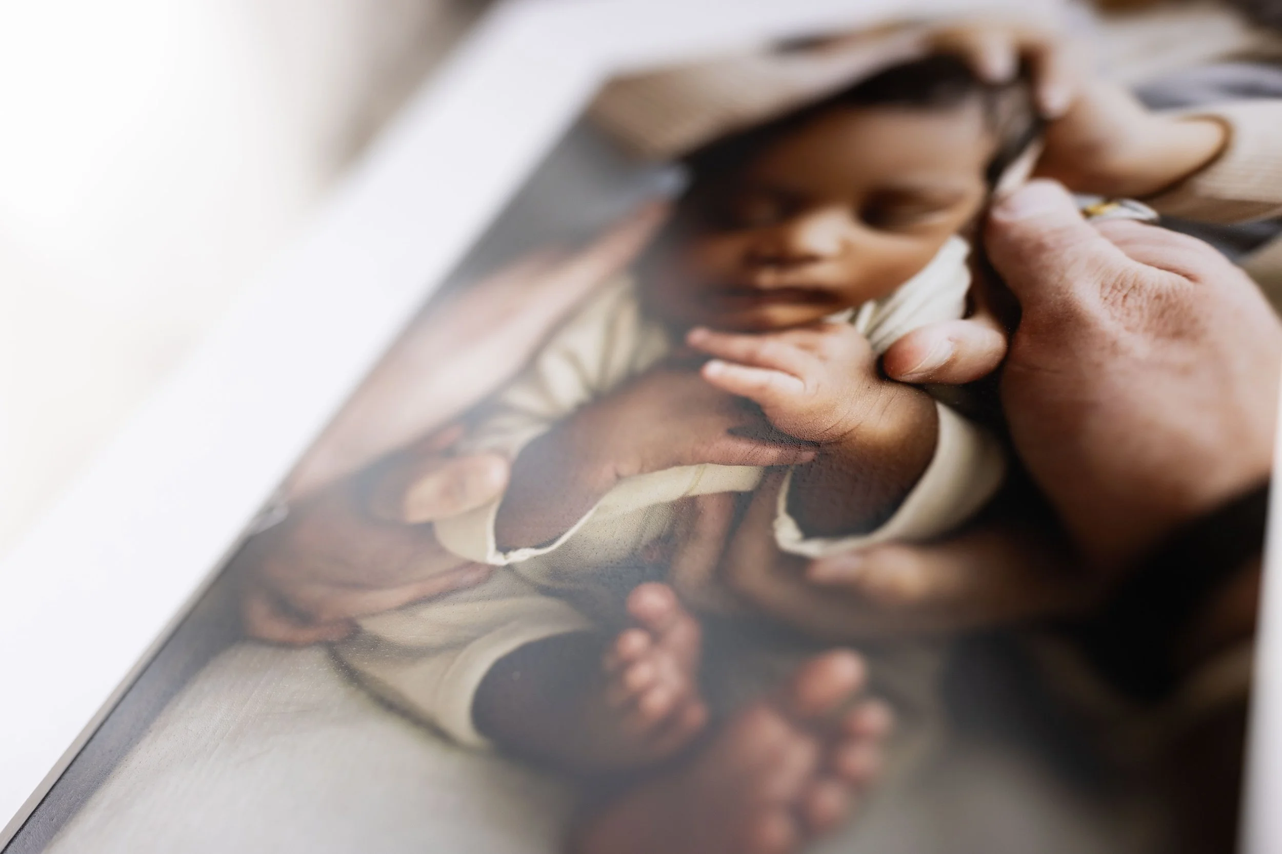 Close-up detail of a fine art newborn print, highlighting the soft texture and depth of professional archival paper.