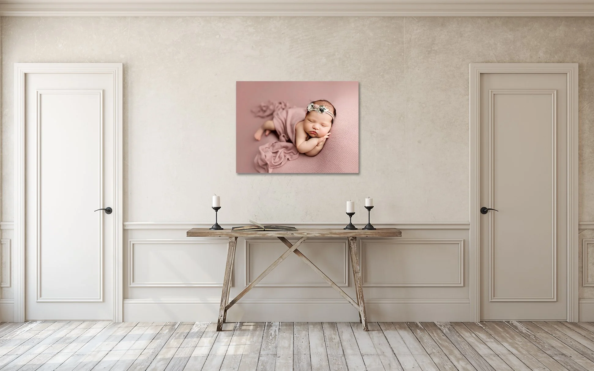 Newborn canvas wall art displayed in a neutral home interior, featuring a sleeping baby posed softly on a blush backdrop