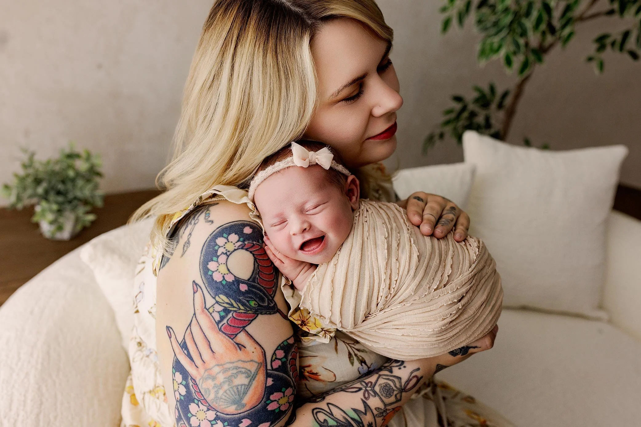 Mother holding her smiling newborn during a lifestyle newborn photography session.