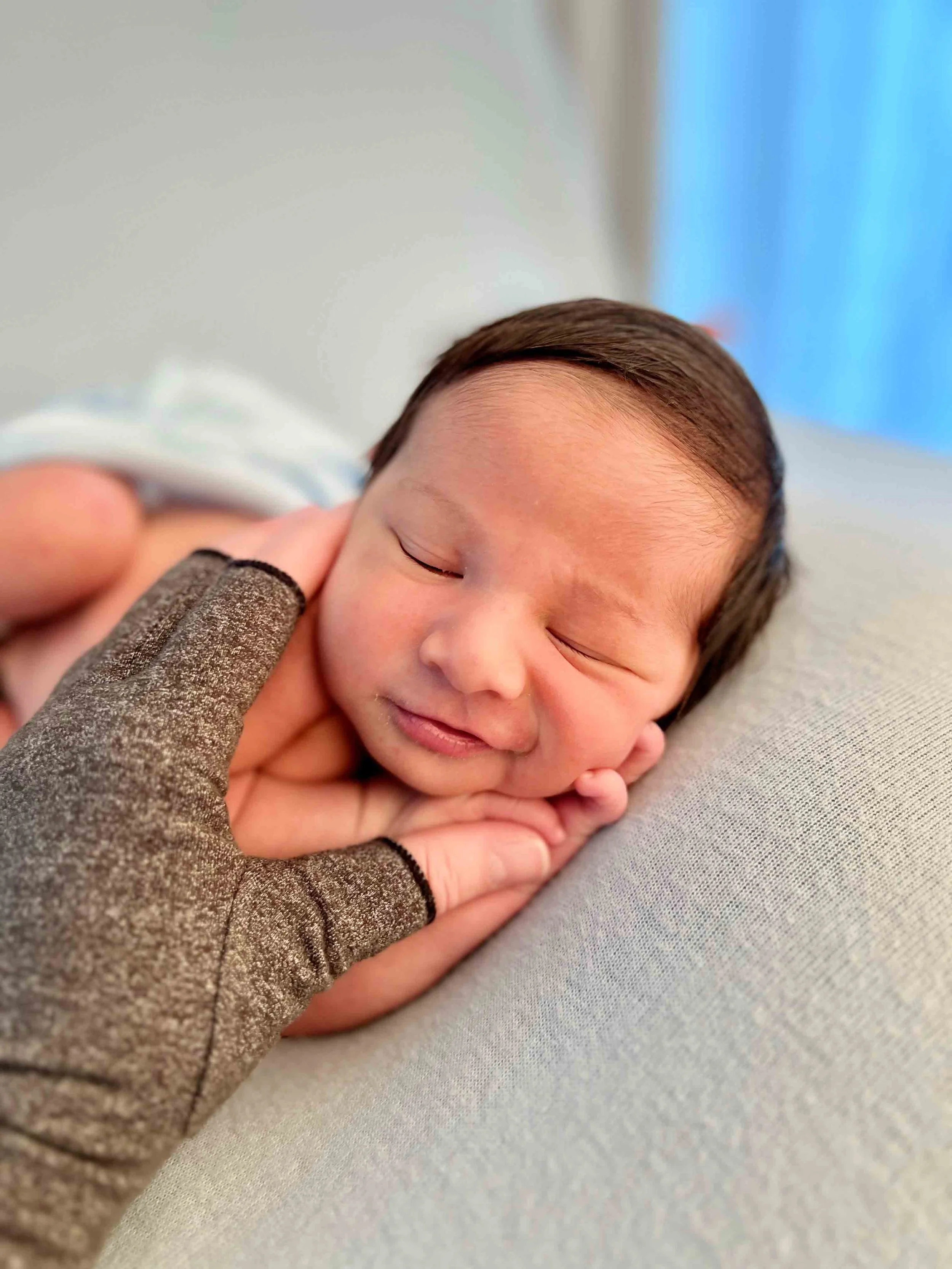 Close-up of newborn safely supported during professional photography training focused on posing and safety techniques