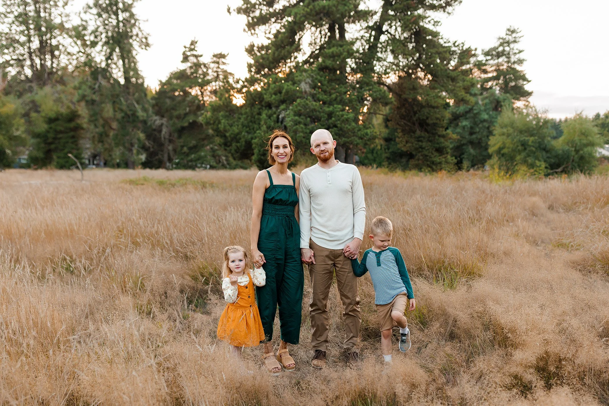 Family of four standing in golden field at sunset in Salem, Oregon during relaxed outdoor family photography session