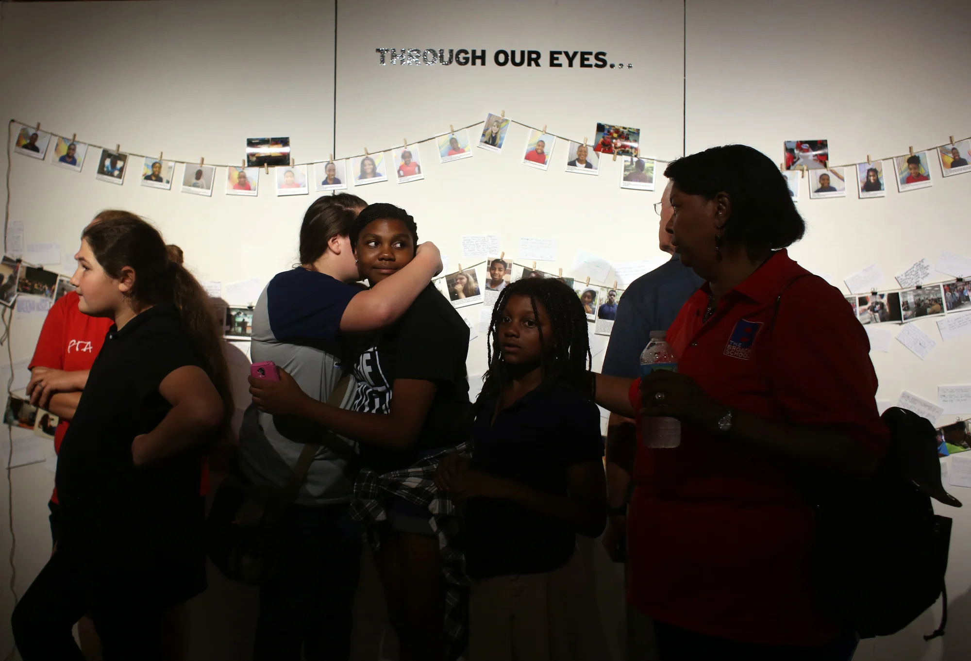 (center) Gracie Gordy, 13, hugs Kaylee Pompey, 13, both John Hopkins middle school students, at the opening night of Through Our Eyes: Midtown and Beyond on Friday November 6, 2015 at Studio 620 in downtown St. Petersburg.
The exhibit features photographs and multimedia work of students from Melrose Elementary, John Hopkins Middle, and Lakewood High School.
On Sunday November 8, at 3pm, there will be a poetry slam in the exhibit at Studio620