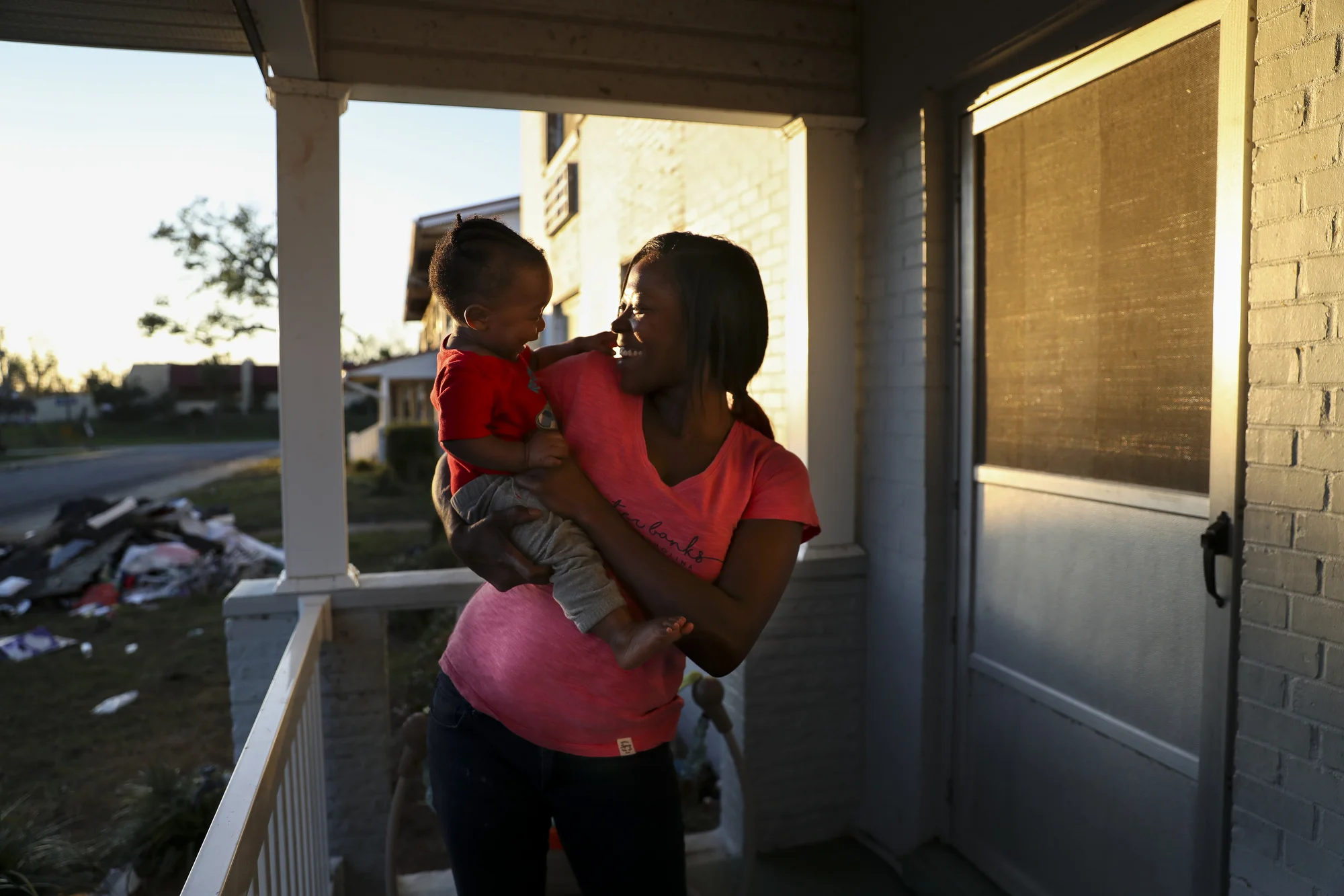 Latoya Jackson tickles her son Benny, 11 months old, in front of her apartment at Massalina Memorial Homes on December 4, 2018 in Panama City, Fla. Jackson rode out Hurricane Michael in a closet in her two-bedroom apartment with her two kids. Everyone in the complex was asked to relocate even though some units suffered minimal damage. Jackson cannot afford to leave.