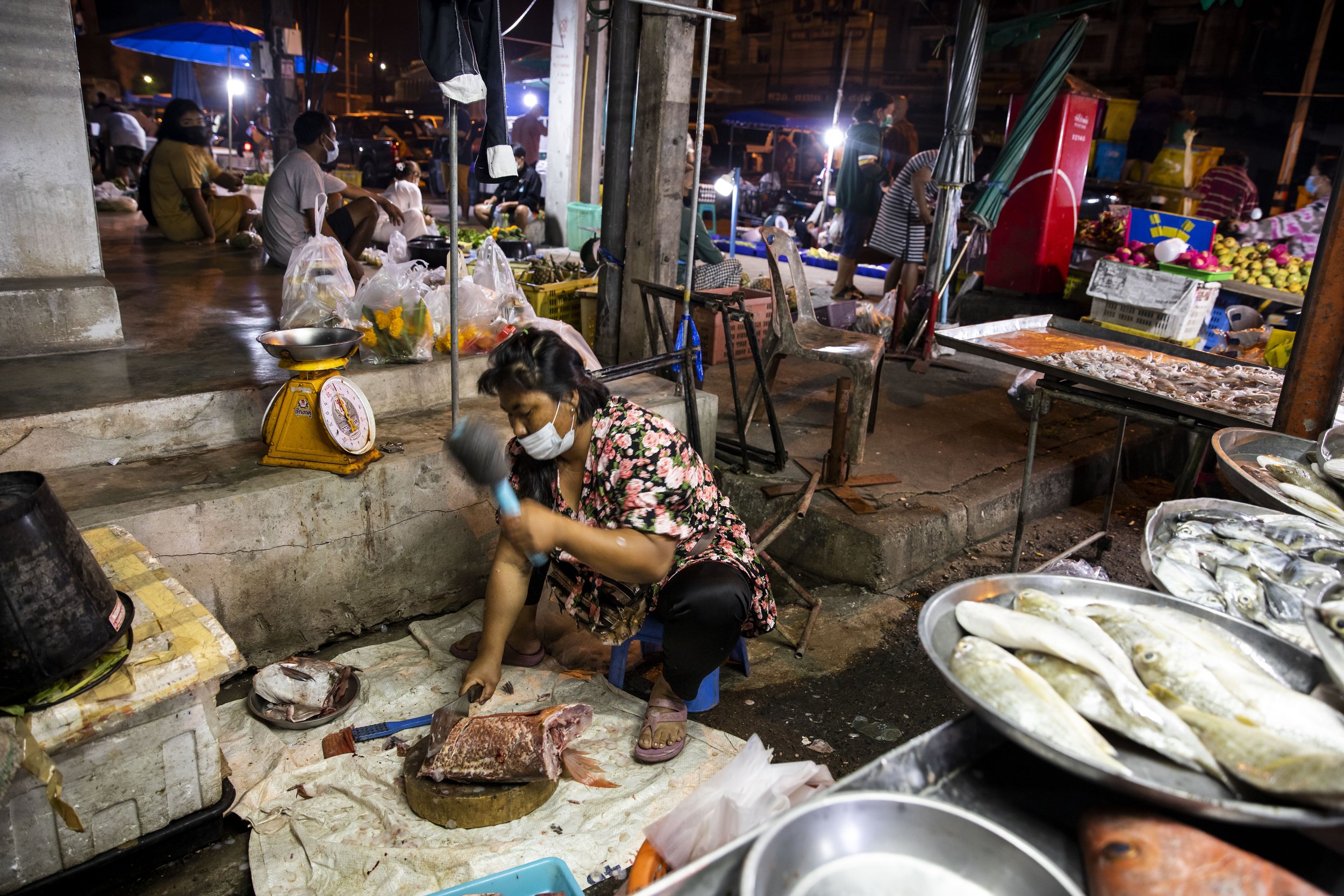  During an early morning market, a fish vendor filets a red snapper for Chutatip “Nok” Suntaranon (not pictured) in Yantakhao, Thailand on Saturday, April 16, 2022. The market in Yantakhao starts very early in the morning to accommodate the schedule 