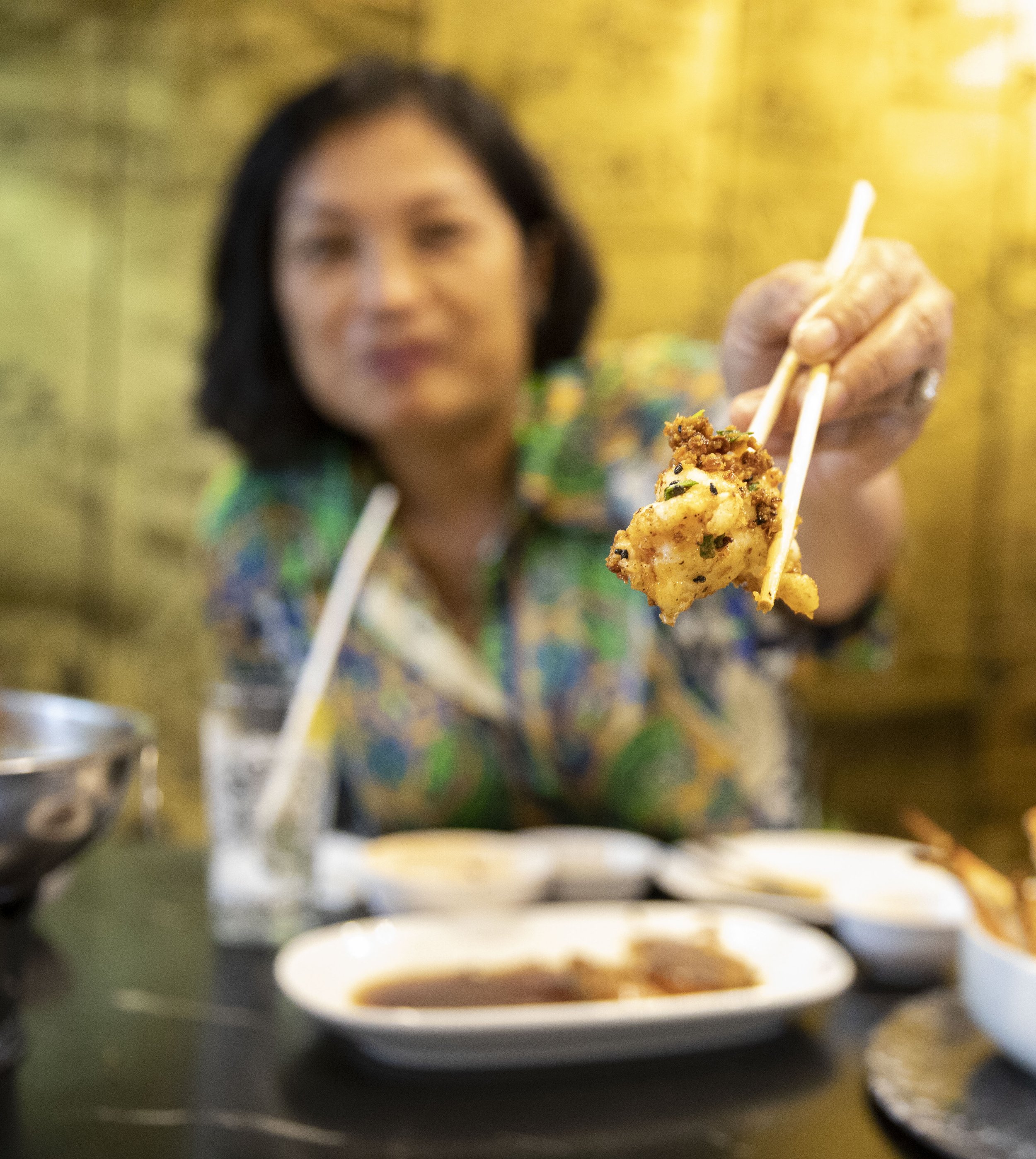  Chutatip “Nok” Suntaranon shows off a piece of wok fried Phuket lobster at Chef Gigg Kamol's restaurant in Bangkok, Thailand on Thursday, April 21, 2022.  