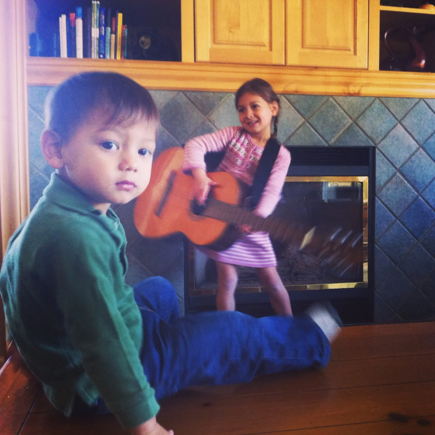 My son listening to his sister's impromptu guitar concert 