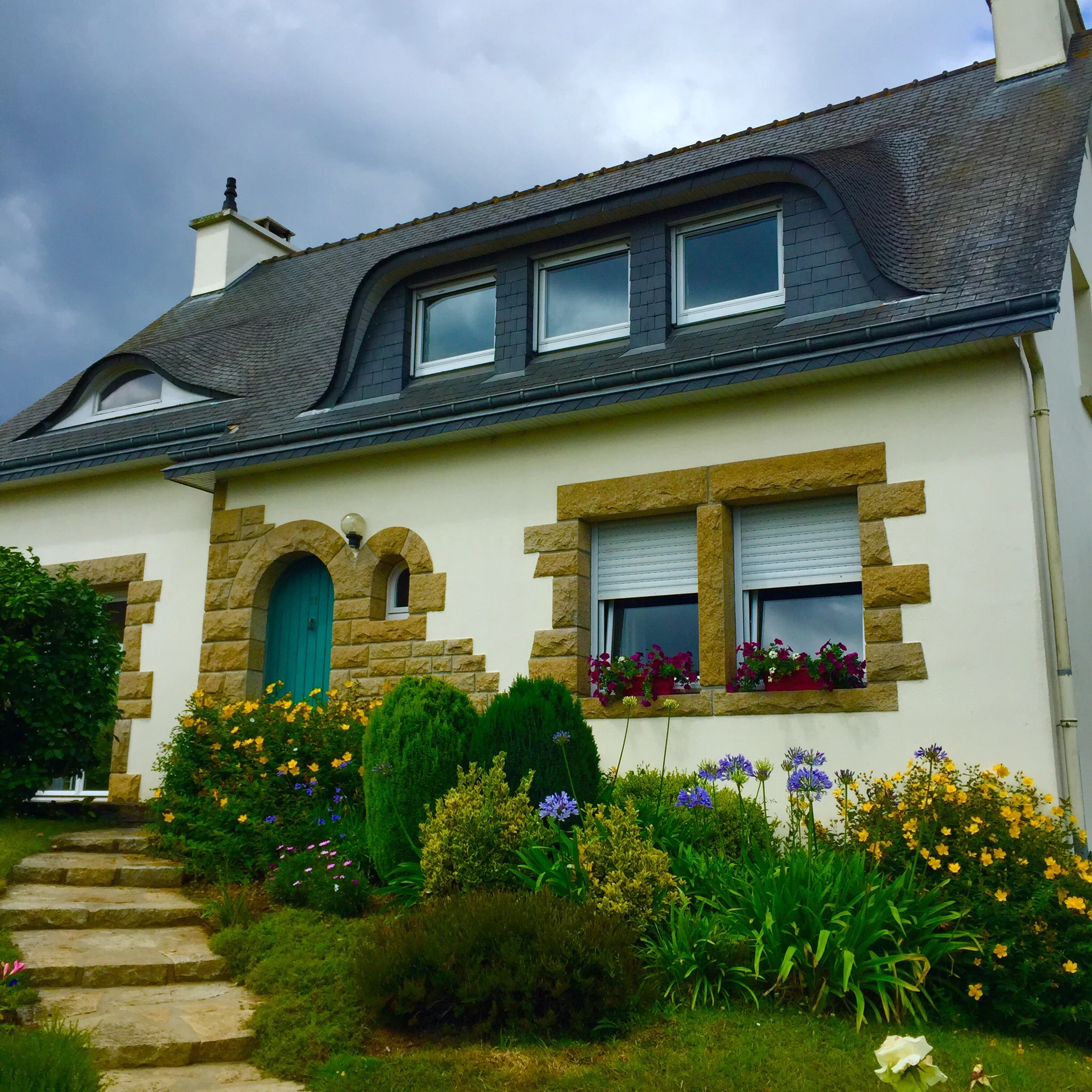 A typical Breton house in Brittany--rounded door, white walls, stone accents, and such charm