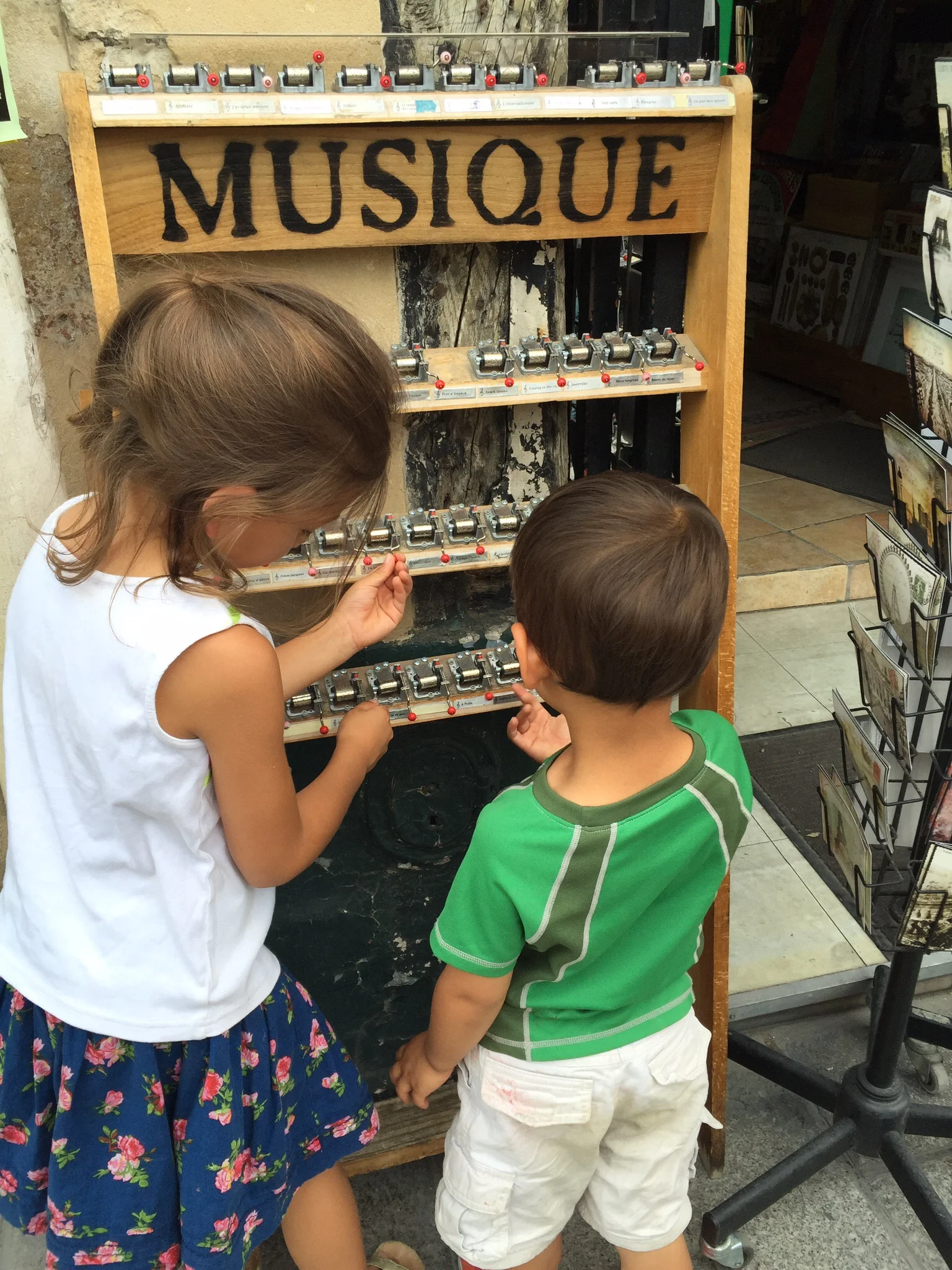 My children testing out the music boxes near Notre Dame de Paris 
