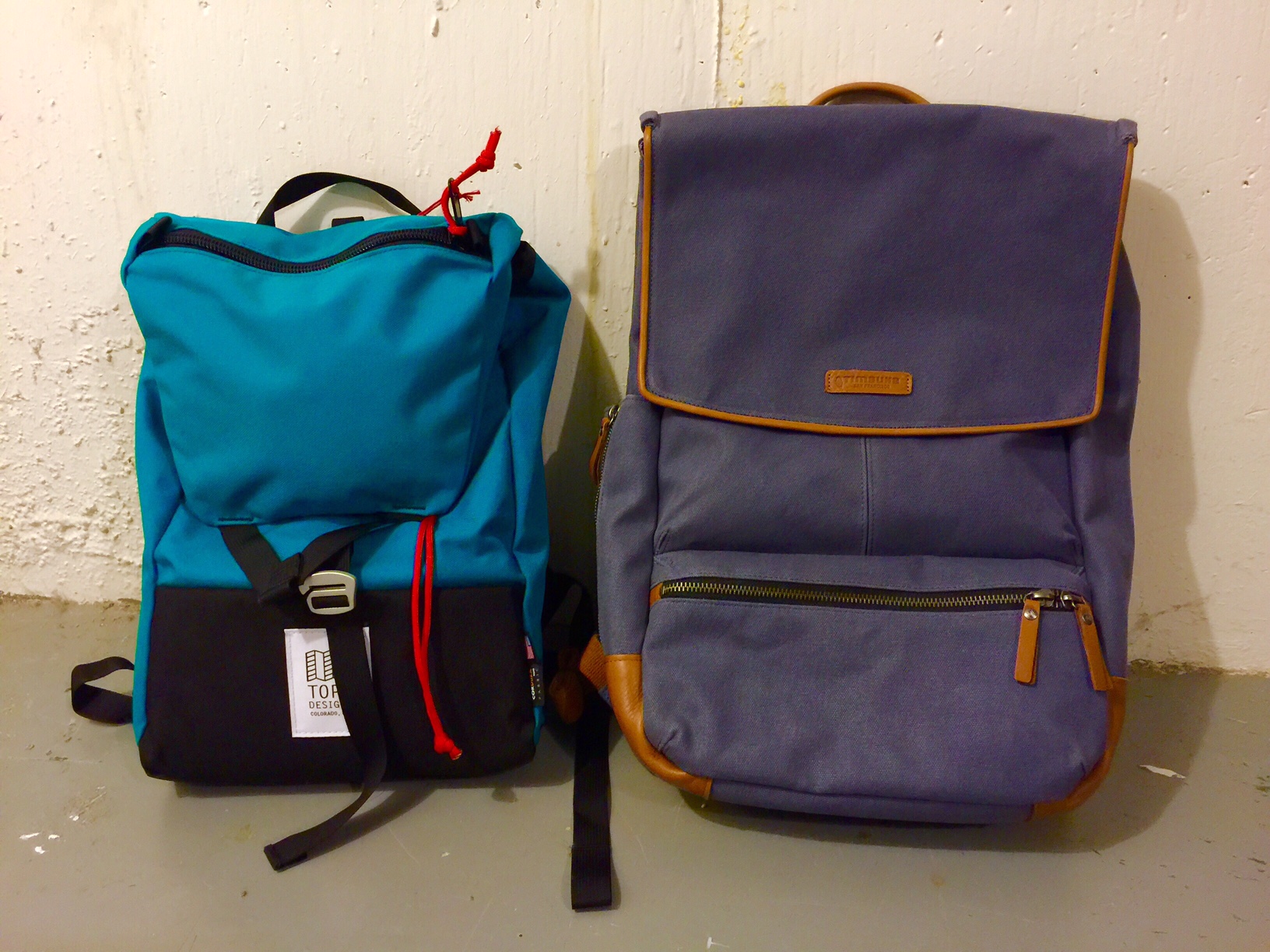 Left: Topo Designs Y-Pack (named for its strap & closure, presumably) in turquoise. Right: Timbuk2 Walker, 2014 model, in midnight. (Photo color-corrected due to cold, poor lighting.)