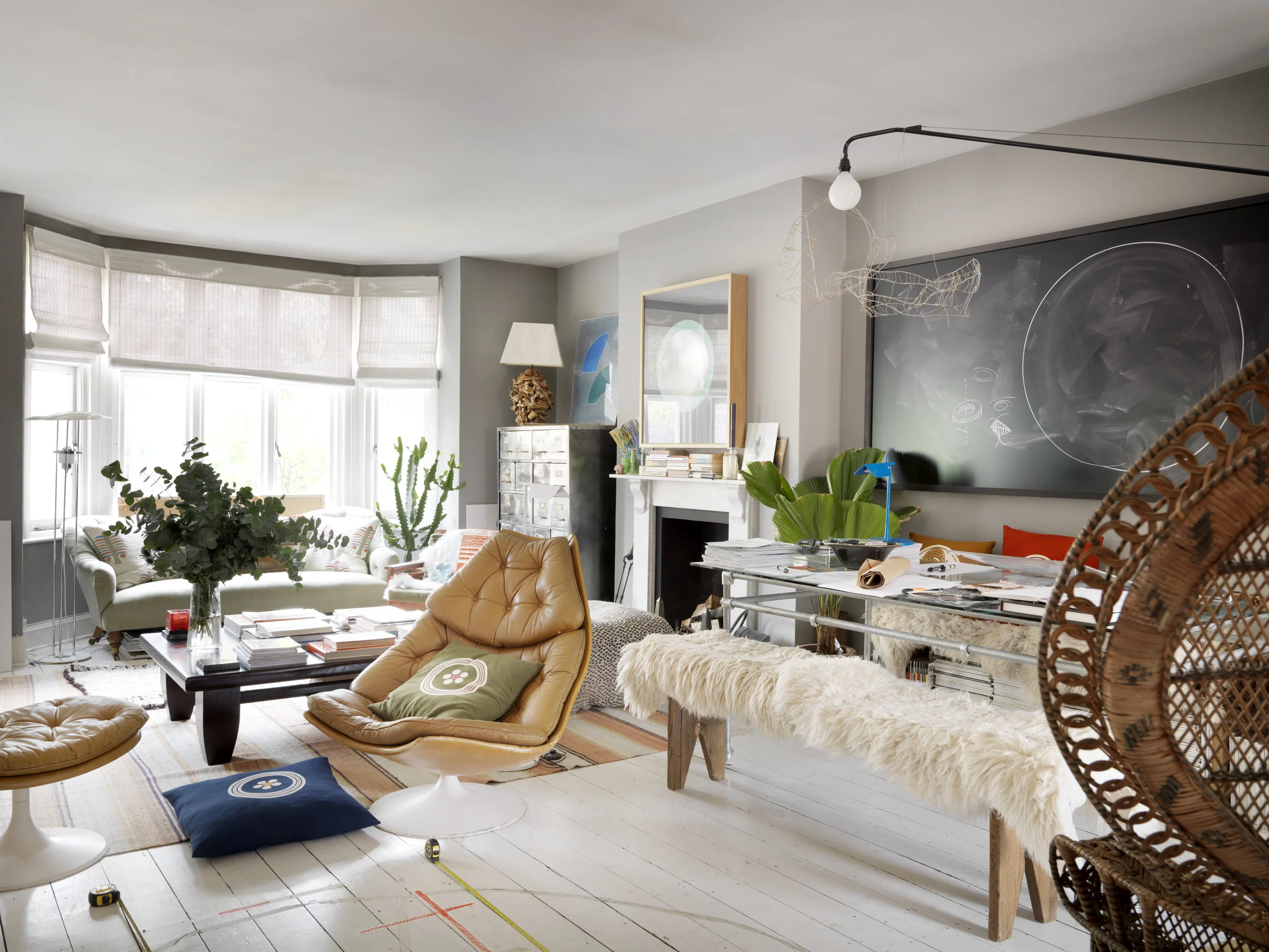 In the living room, a Geoffrey Harcourt swivel chair sits against a photograph by the Spanish artist Alejandro Guijarro . The floor boards are painted white to add to the mood-lifting space.