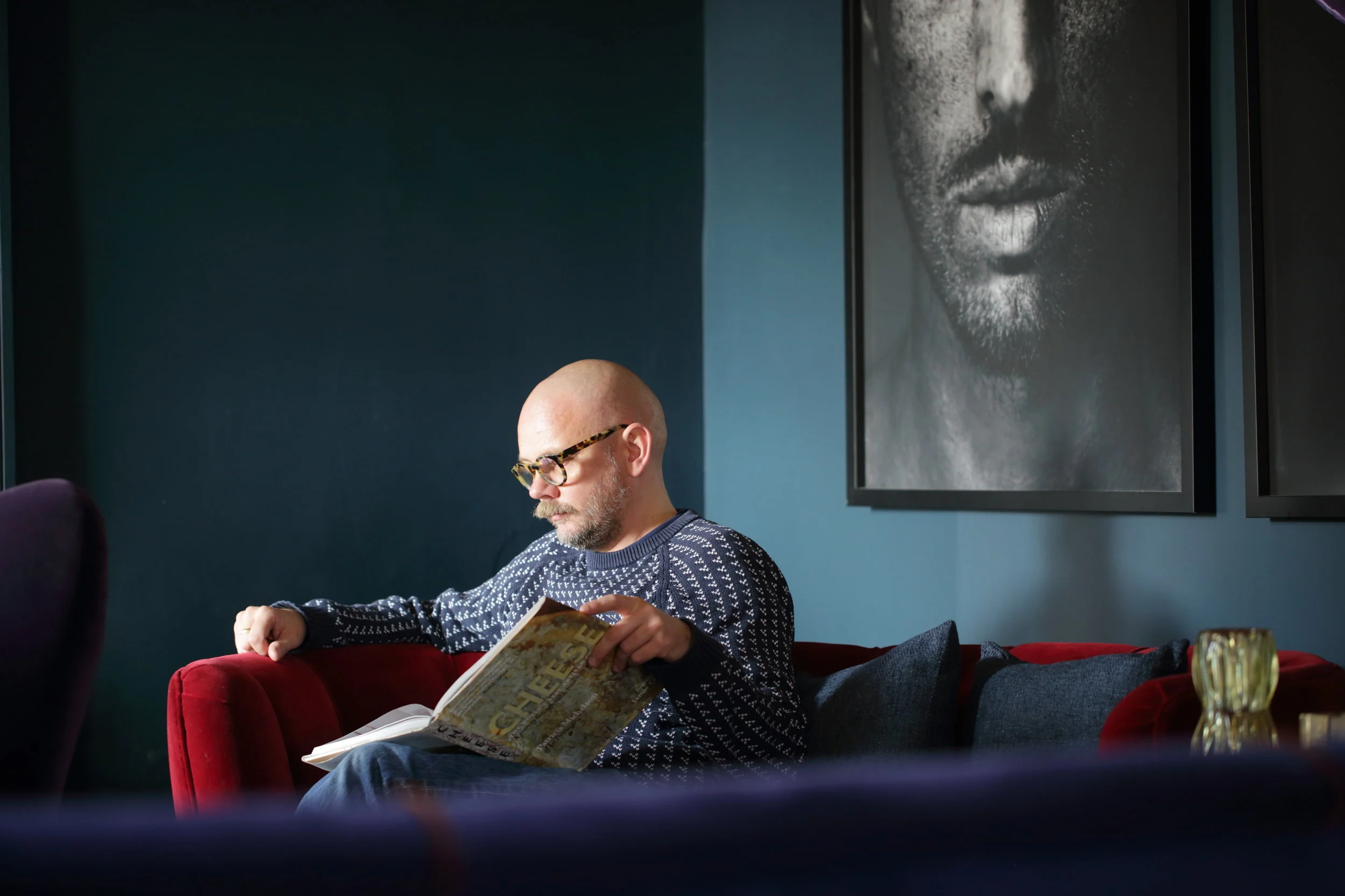 Steiner in his living room, which features a '40s velvet banana sofa and portraits by Dale Grant.