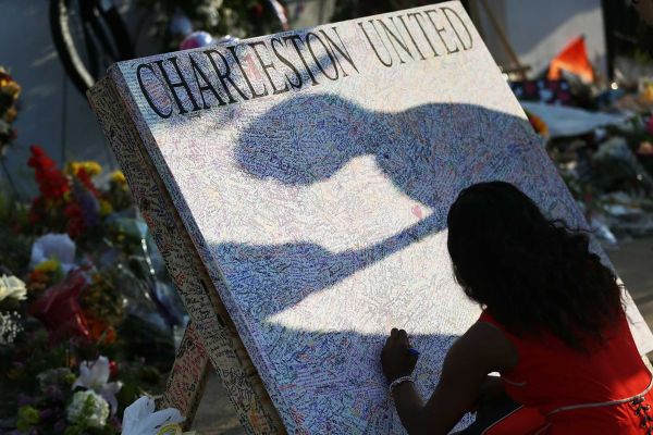 Alana Simmons leaves a message on a board set up in front of the Emanuel African Methodist Episcopal Church after a mass shooting at the church killed nine people, on June 22, 2015. Photo Credit: Getty Images / Joe Raedle