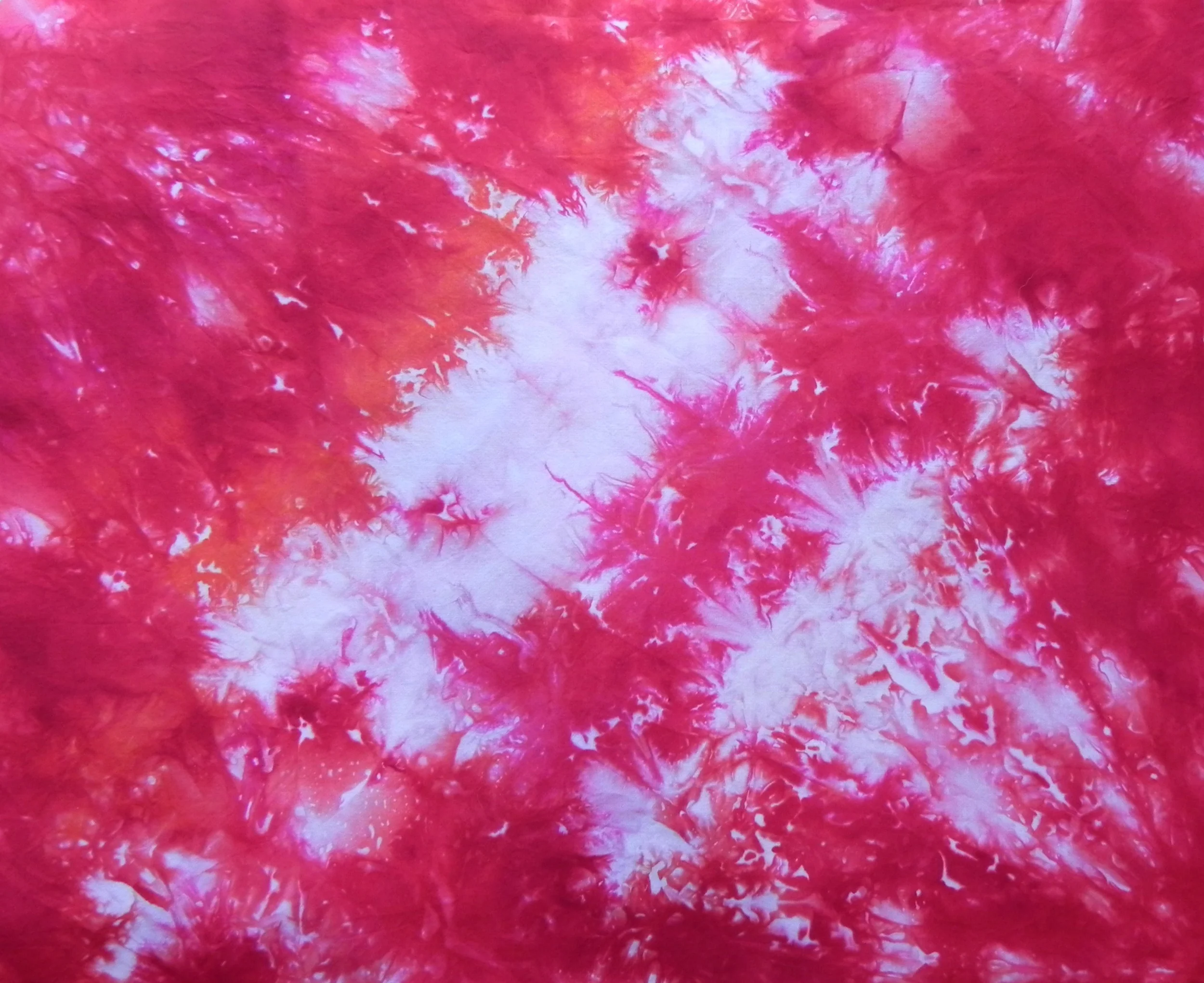 I *think* this was the bottom fabric--I didn't label these. I twisted the fabric and used red and fuchsia dye powders. The orange shows up because this floats in dye water from all layers once the ice melts.