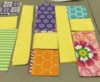 Laying fabrics out to avoid having three of the same pattern appear in a single block, like they do above. (This got changed before sewing!)