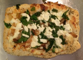 Saturday Lunch pizza--his dough, his stretching method. It looks more pale in this picture than it was. I always brush olive oil with herbs and garlic on the crust right before and immediately following baking, so that's what you're seeing on the crust. This version: Parmesan cream sauce, caramelized onions, spinach, and goat cheese. Yum!