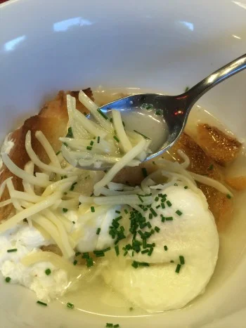 Parmesan broth with toast, a poached egg, shredded Gruyere, and chives. 