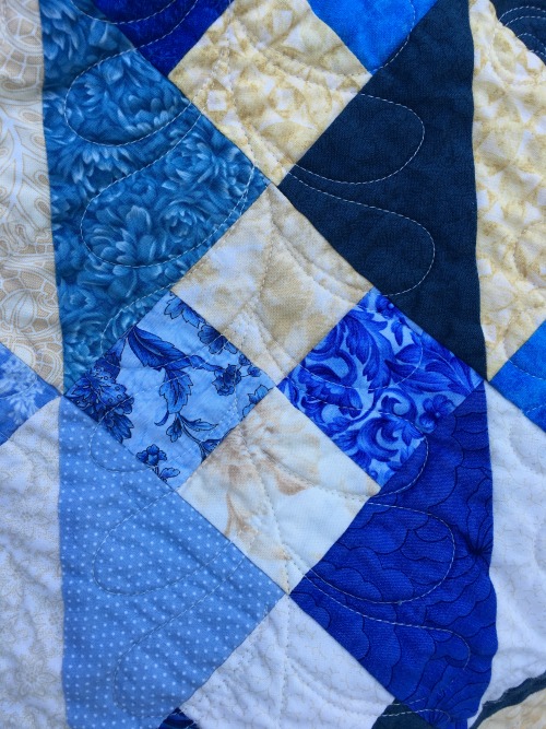 She used a variation of the interior block quilting design in the parts of the block that end up looking more like sashing. Very effective.