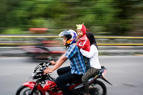 Bali Documentary Photograph, Balinese family with baby riding a motorbike in Ubud