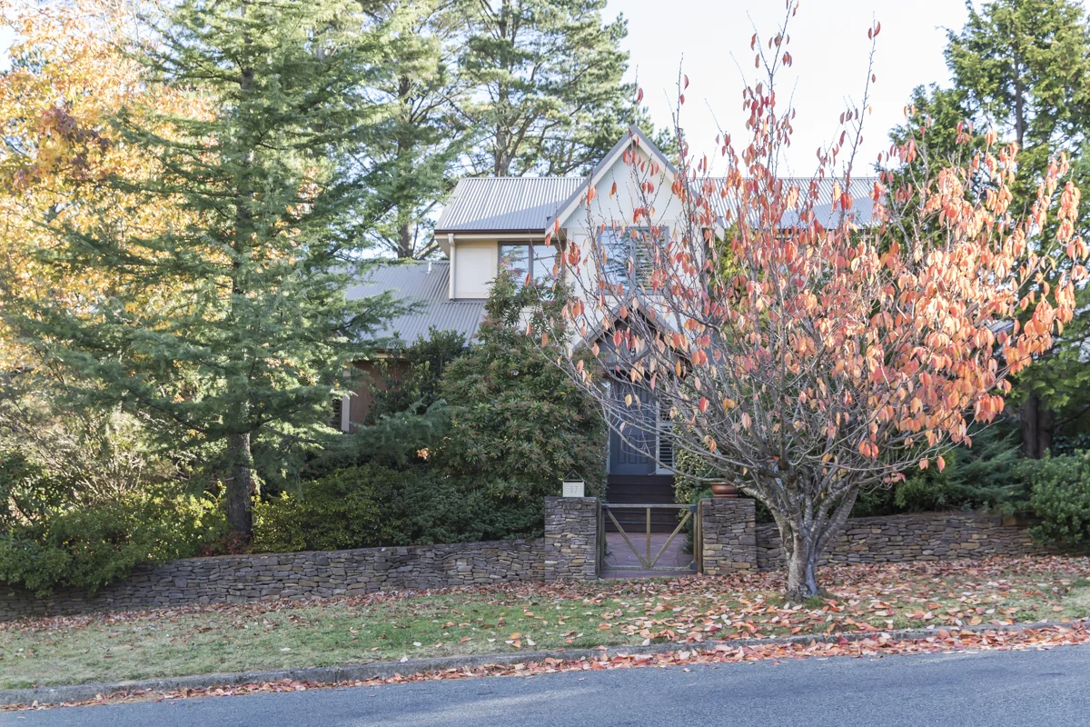 Stonelinks House in autumn, framed by red and gold trees