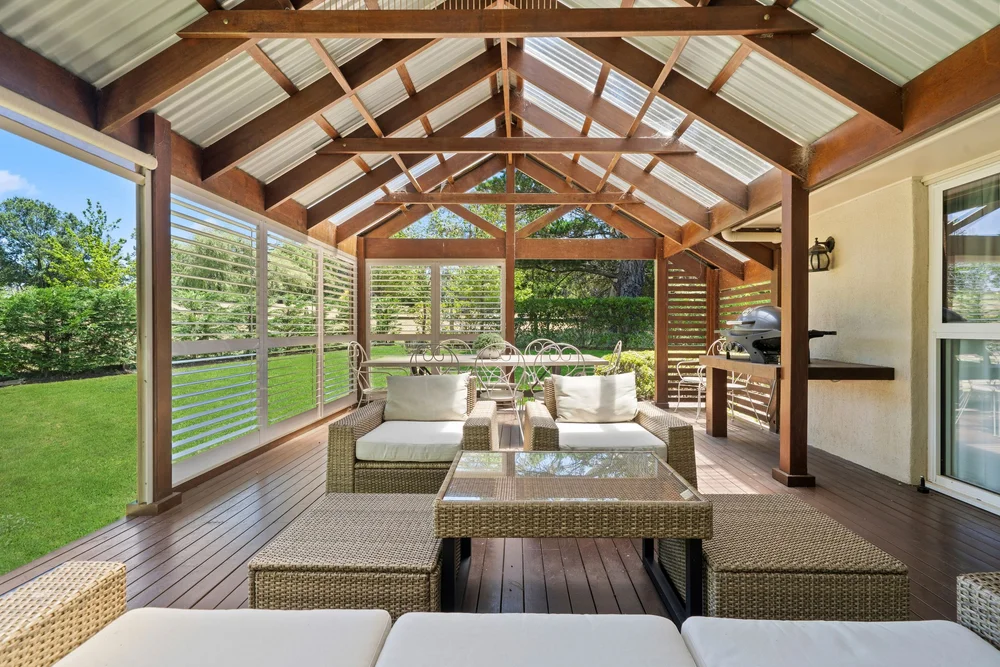 Covered loggia with wicker lounges and garden views
