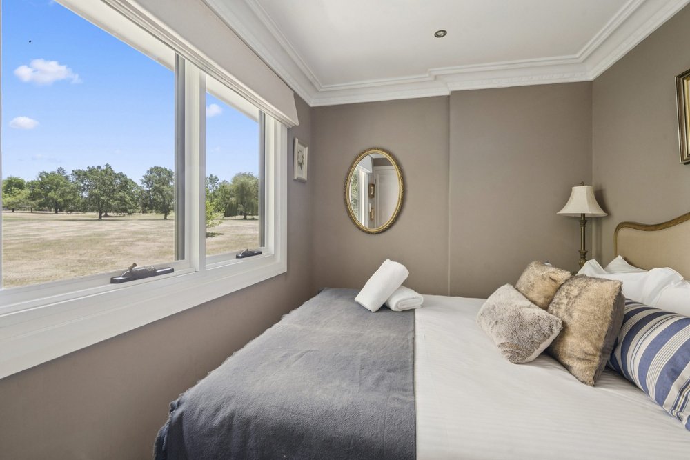 Bedroom 4 with a queen bed beside a large window