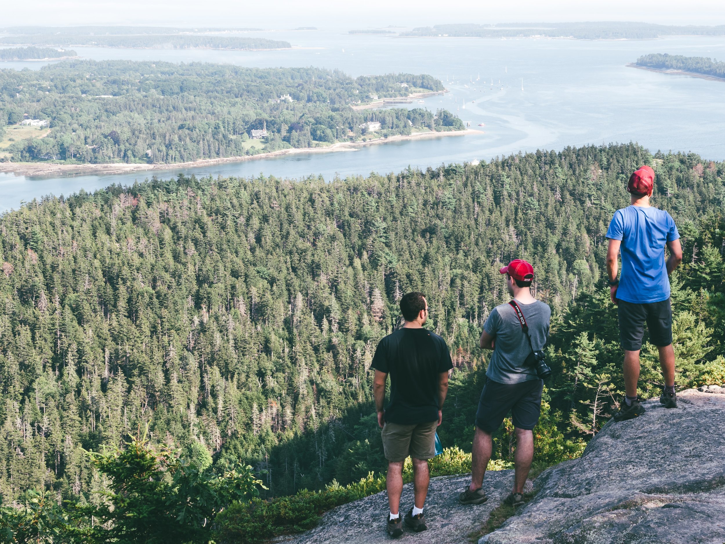 John, Brandon, and Luis look out over Acadia National Park from the summit of Mt. Sauveur.