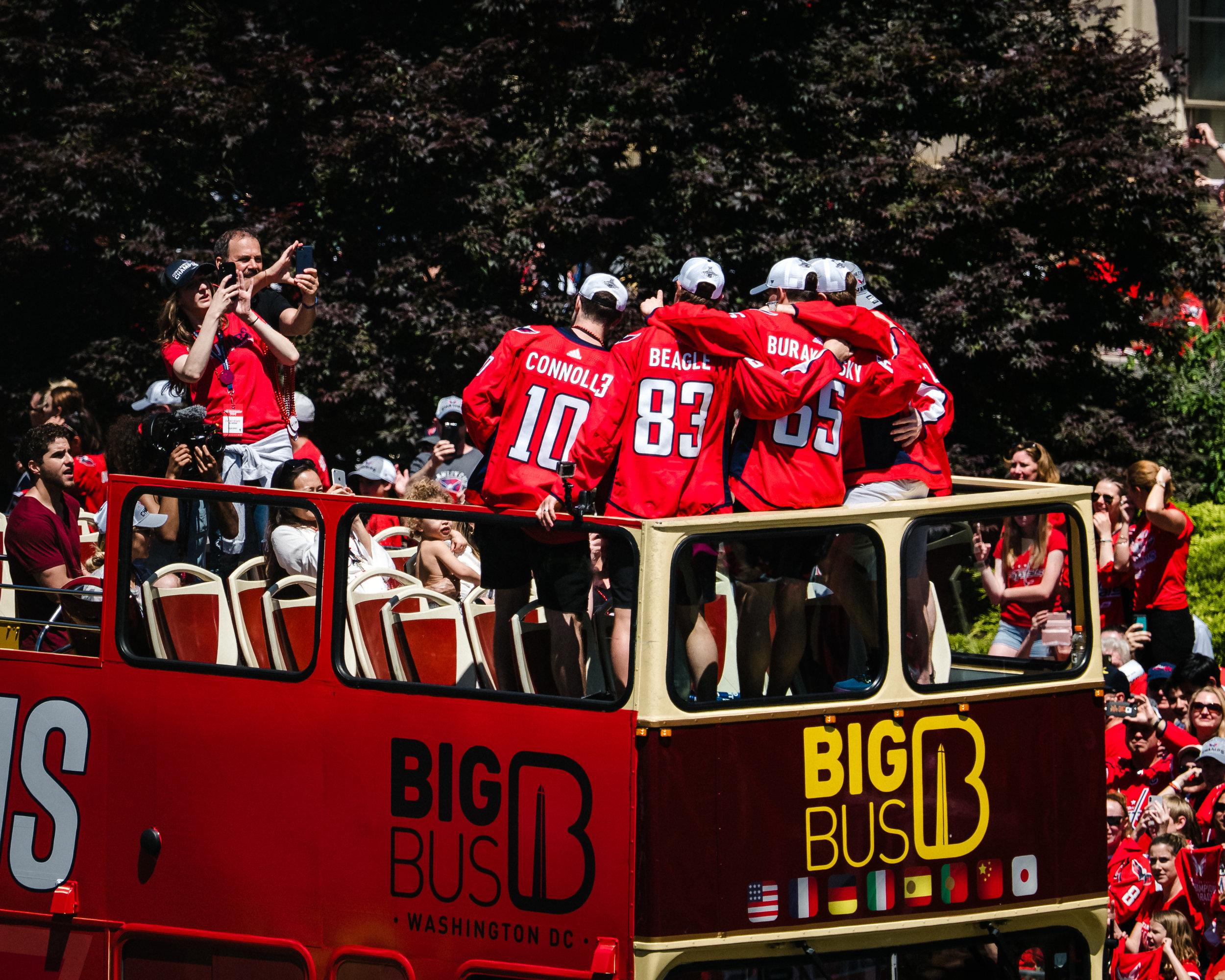 A few of the Washington Capitals (Brett Connolly, Jay Beagle, Andre Burakovski, and more) pose for a photo atop their parade bus.