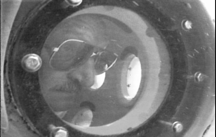 Frank Mays peers out of the porthole of the submersible delta 1995