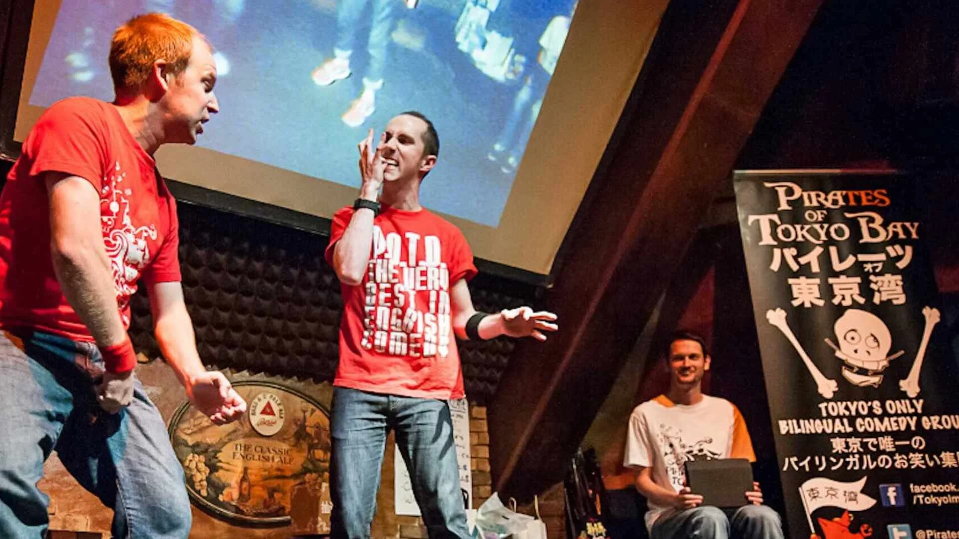 `Two improv comedians creating a scene from an audience suggestion at a Pirates of Tokyo Bay show in Ebisu