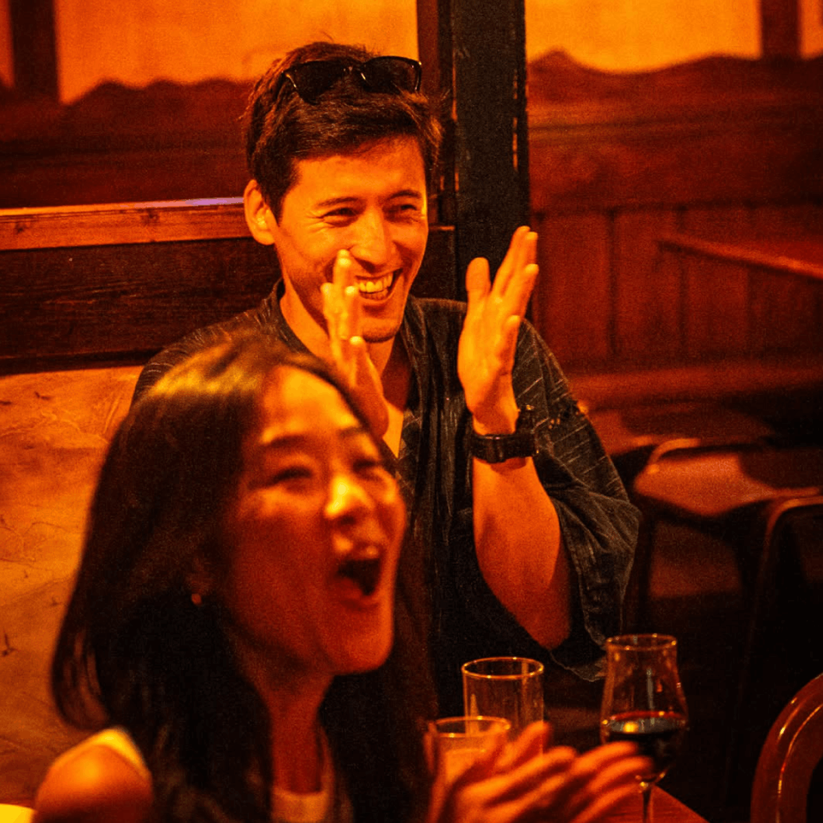 Couple in the audience laughing together at a live English and Japanese improv comedy show in Ebisu Tokyo