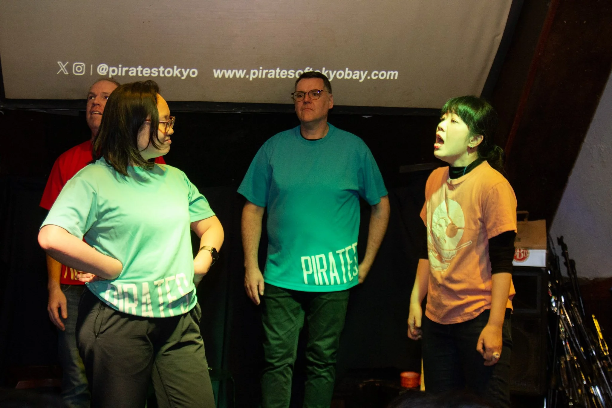 Non-professional performers from everyday careers performing improv comedy on stage with Pirates of Tokyo Bay